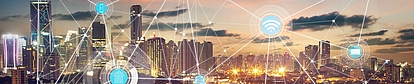 Smart city network with wireless spectrum icons at sunset Illuminated city skyline with overlaid wireless and spectrum connectivity symbols representing modern spectrum regulation.