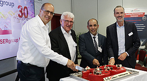 Representatives of LS telcom and international customers celebrate the 30th anniversary of the LS telcom USERgroup Conference during a cake-cutting ceremony in Lichtenau, Germany.