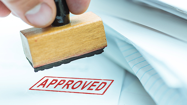 Authority Engineering – Managing Regulatory Approvals for Your Network A close-up of a stamp marking "Approved" on official documents, symbolizing LS telcom’s support in obtaining regulatory approvals for critical communications and private networks.