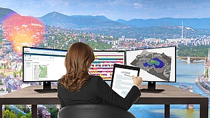Spectrum management services for regulatory compliance Professional reviewing license application and spectrum coverage data on dual monitors with compliance certificate