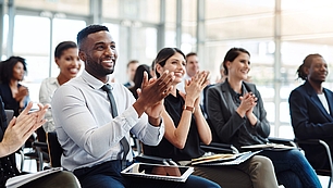 Seminar audience applauds during a professional training session on spectrum-related topics.